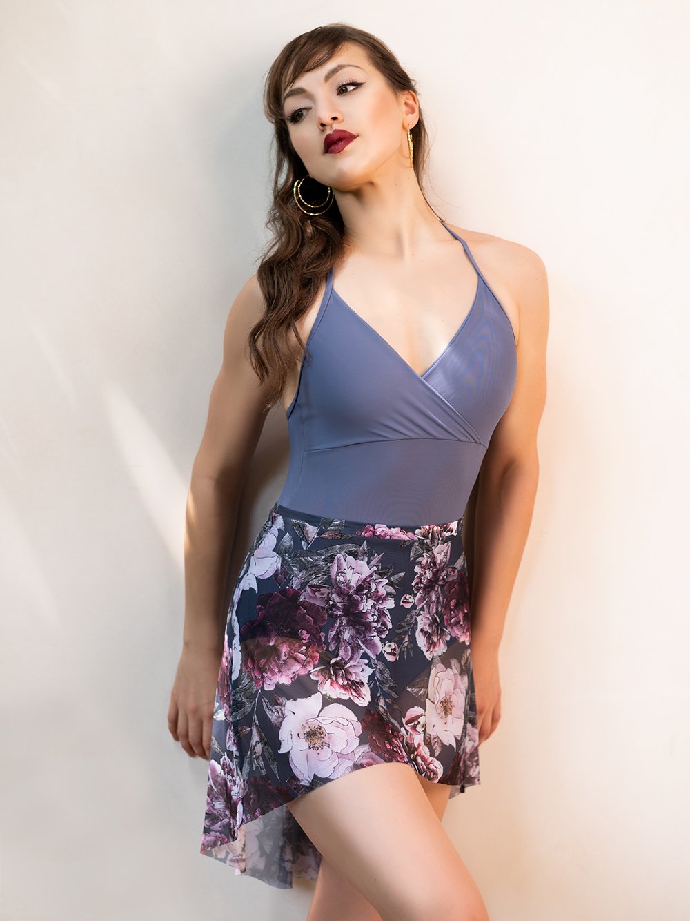 Model wearing a purple leotard with matching mesh skirt