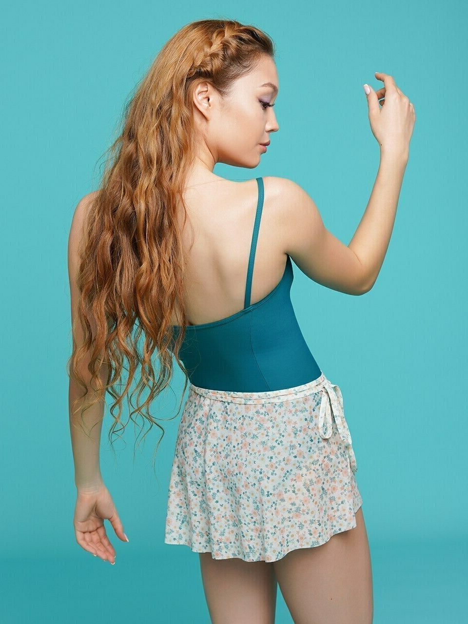 Model wearing a teal leotard with a matching floral wrap skirt