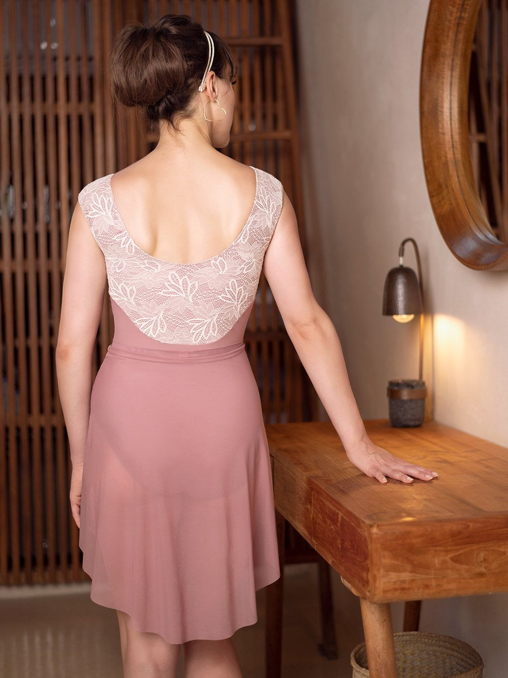 Model wearing a dark pink and lace leotard with matching dark pink skirt