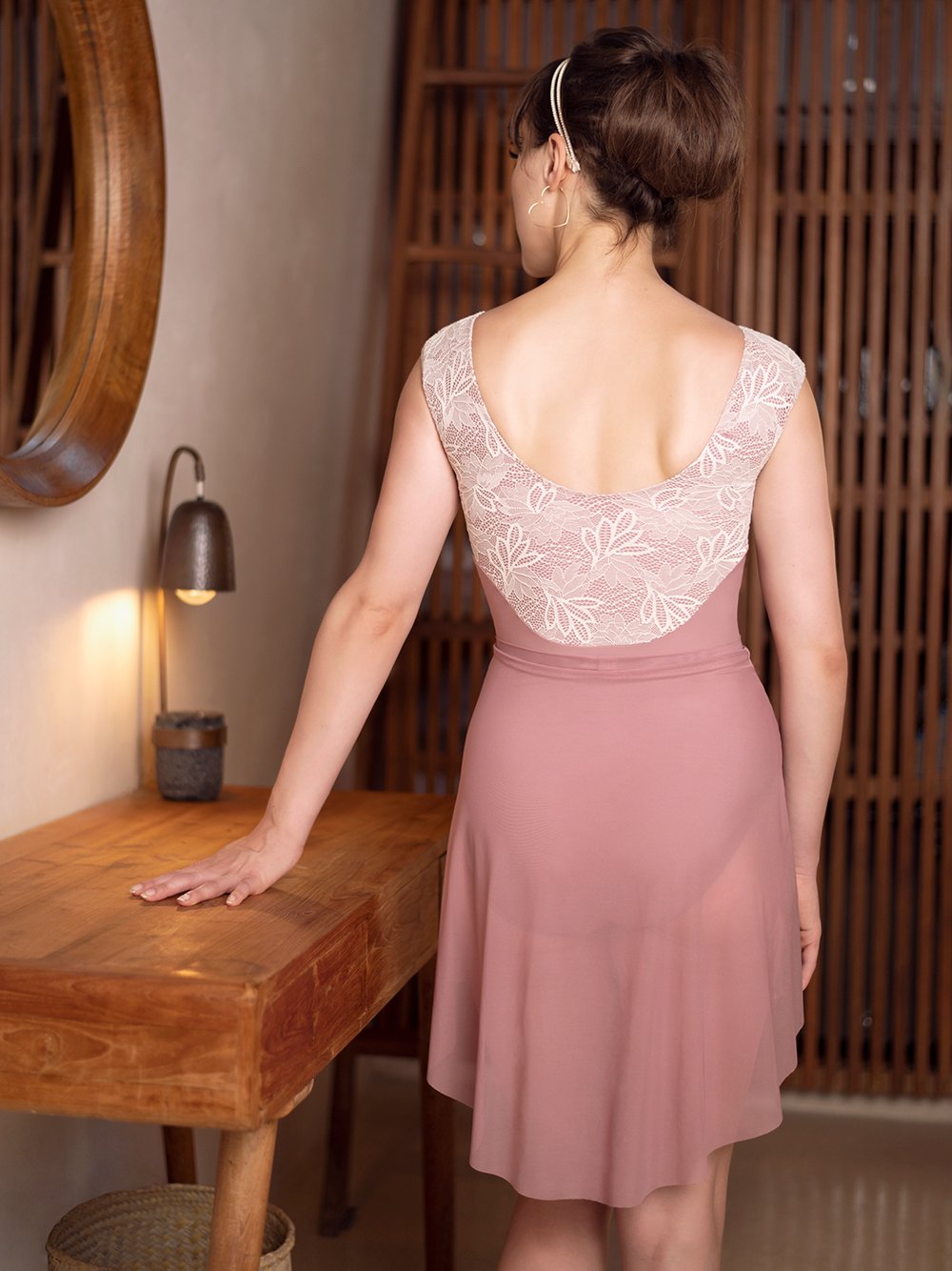Model wearing a dark pink and lace leotard with matching dark pink skirt