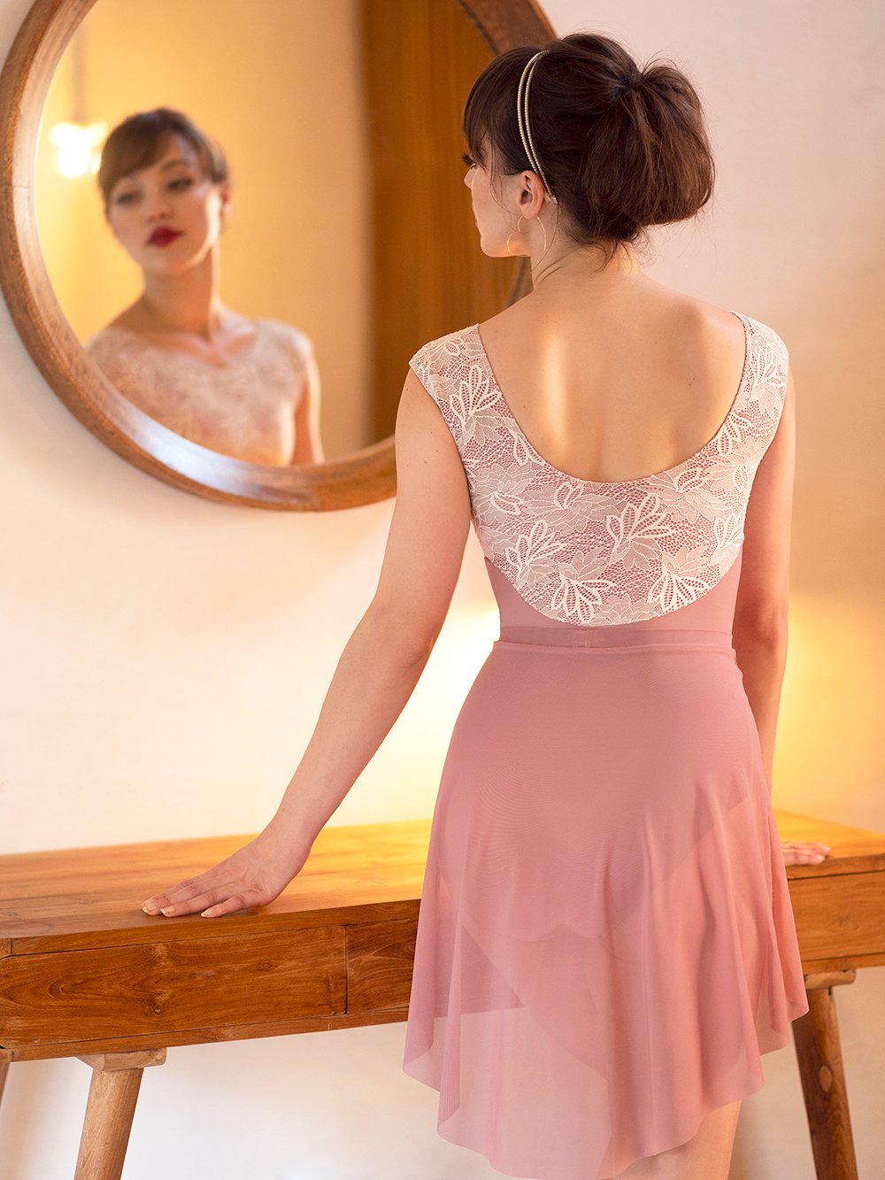 Model wearing a dark pink and lace leotard with matching dark pink skirt