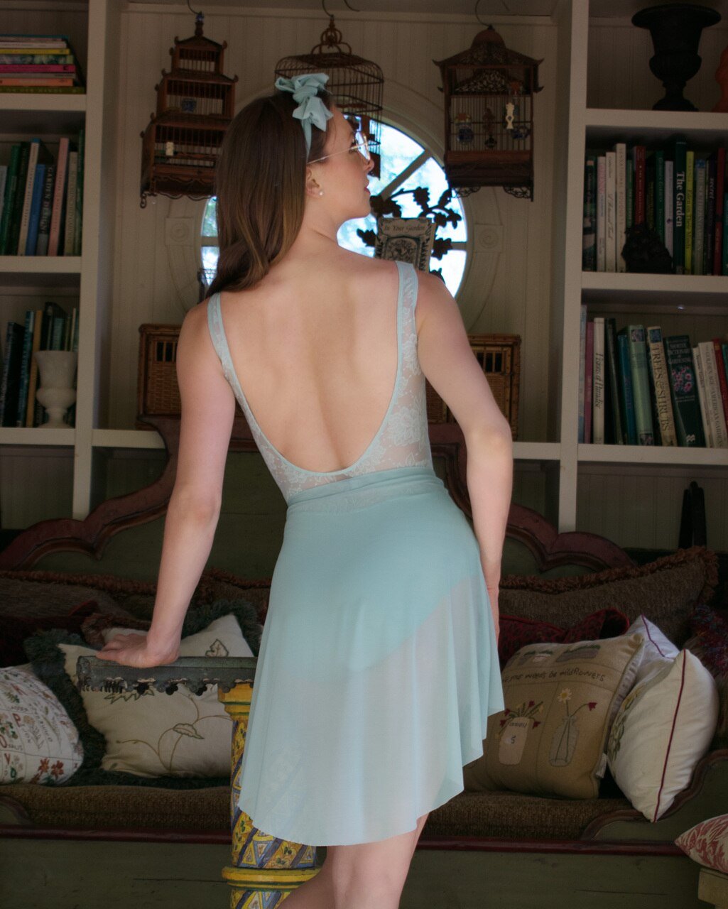 Model wearing a light blue leotard with mesh detail low back and a matching light blue mesh ballet skirt