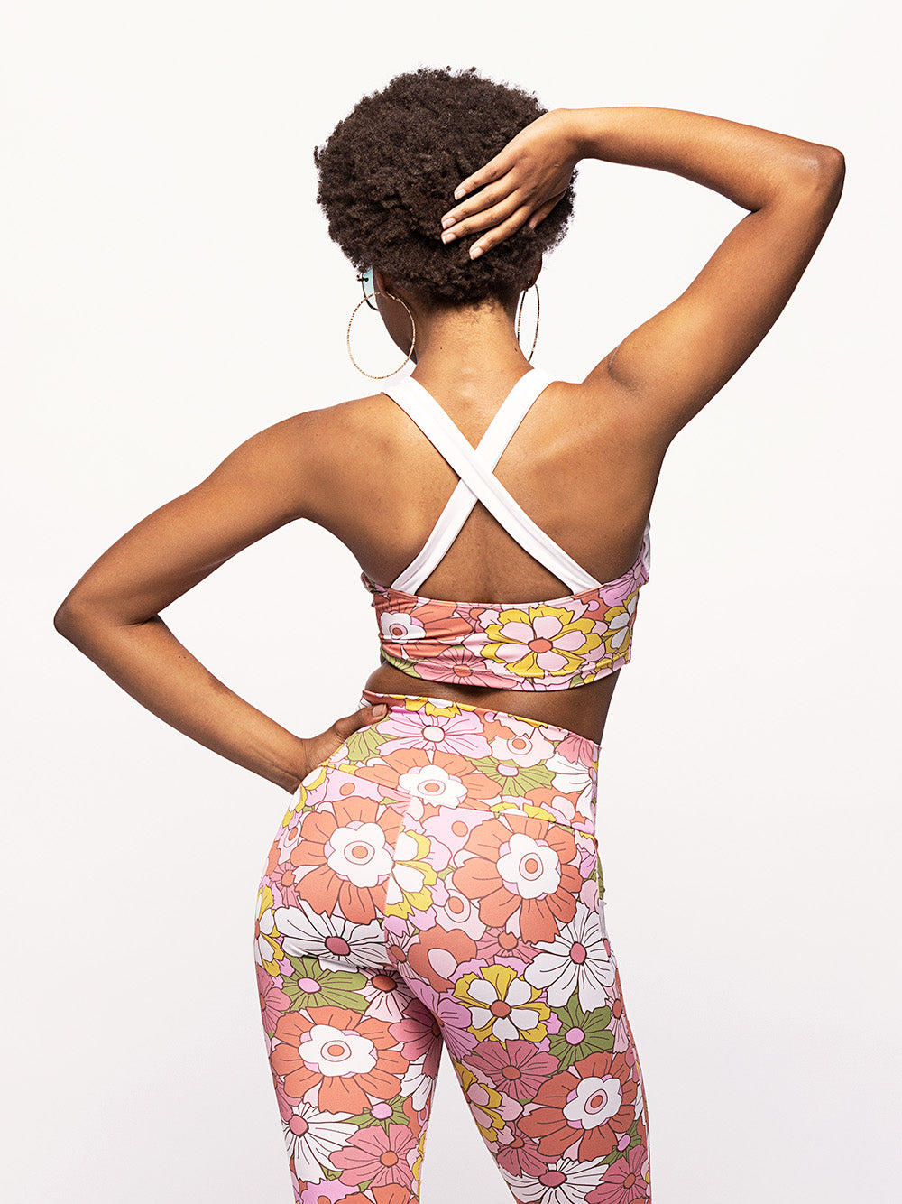 Back close up of model in floral pattern crop top and matching tights