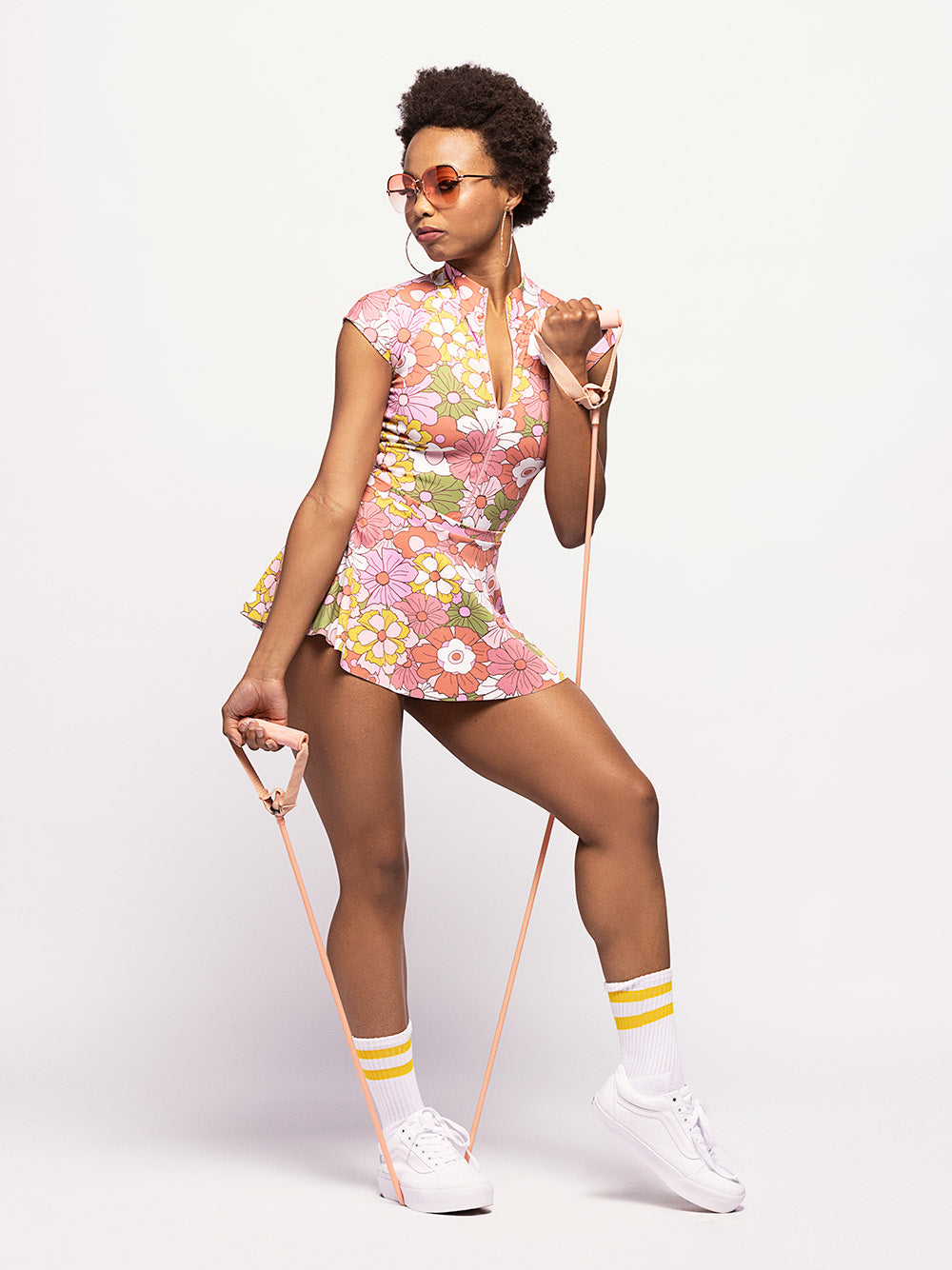 model in floral patterned leotard with zip-up front and matching skirt