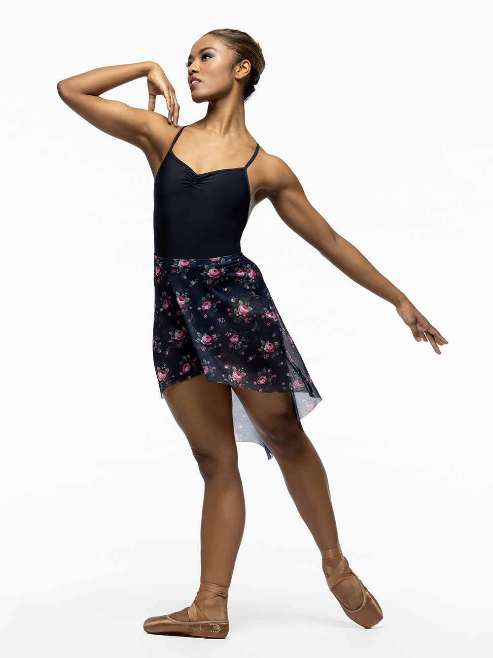 Model is wearing black ballet bodysuit with high low navy blue and pink floral print mesh skirt.
