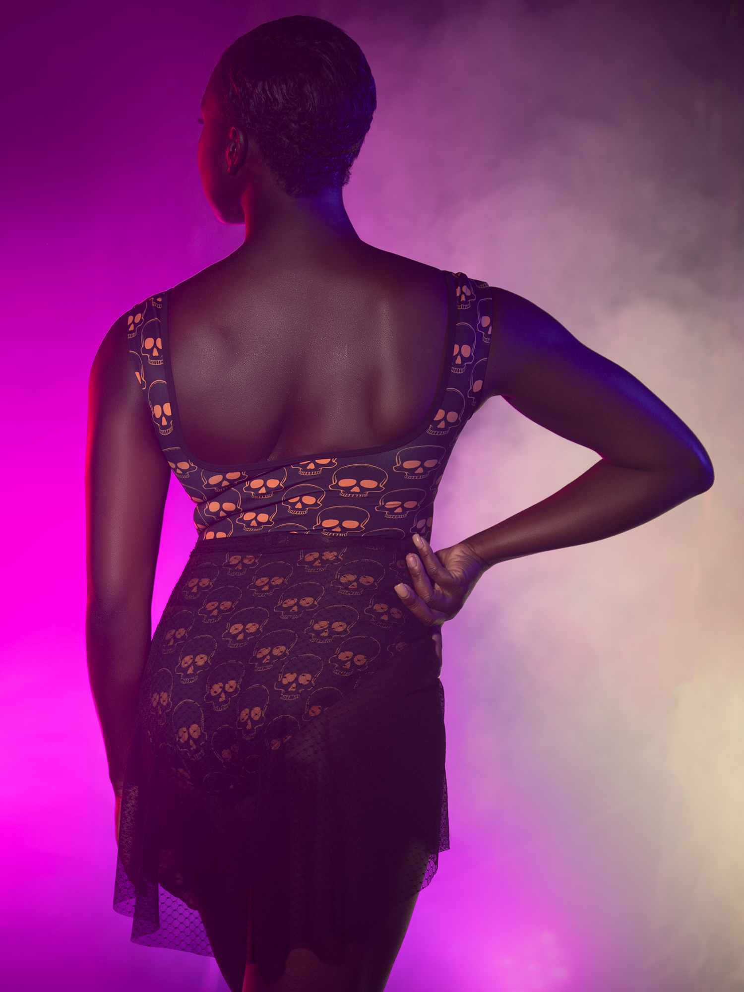 Back view of model in  leotard with orange skulls