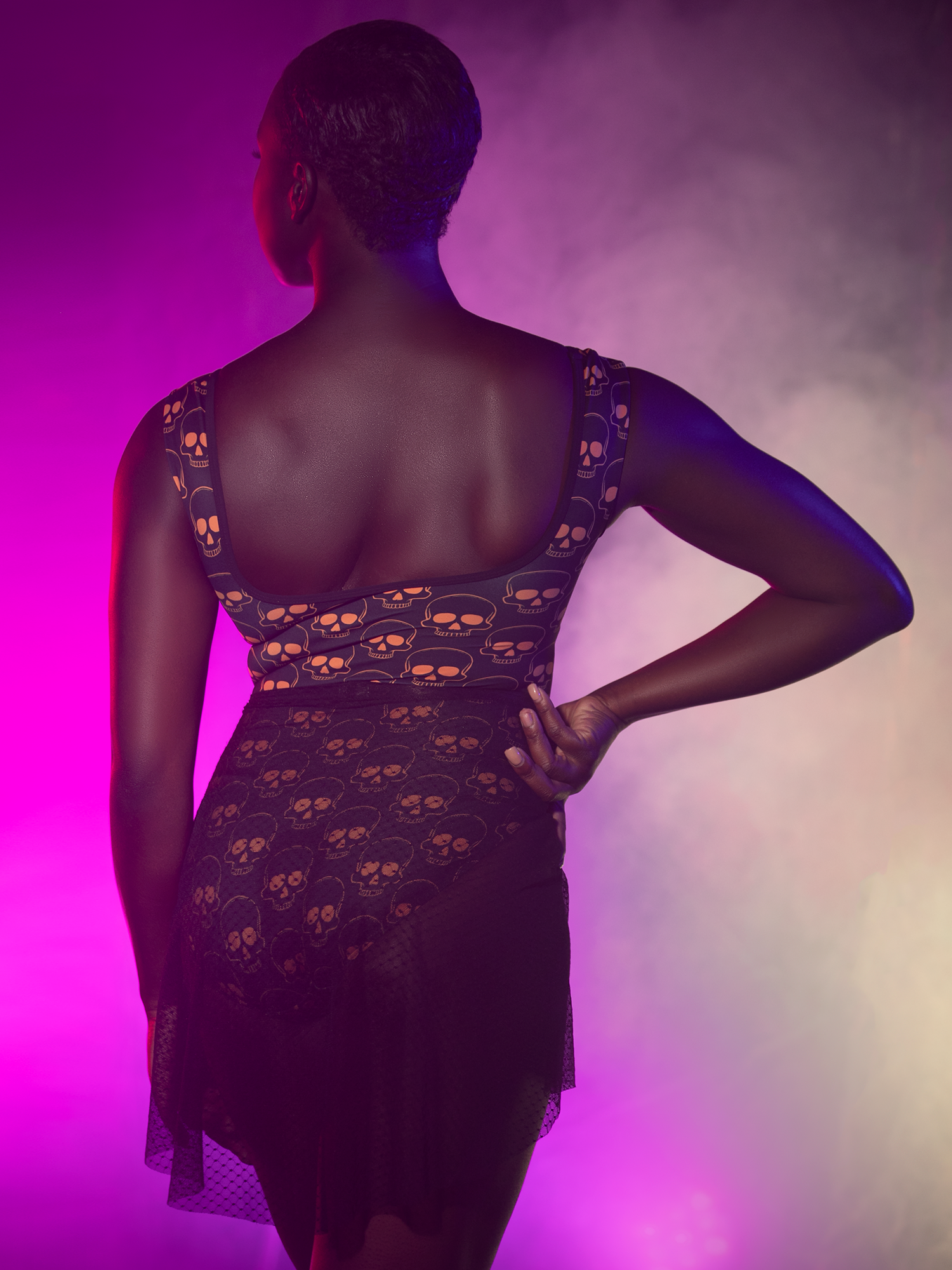 Back view of model in  leotard with orange skulls