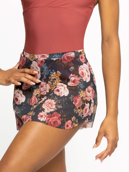 Model is wearing a dark cinnamon pink leotard with a wrap top and cami straps and a Symphony blue floral print mesh skirt