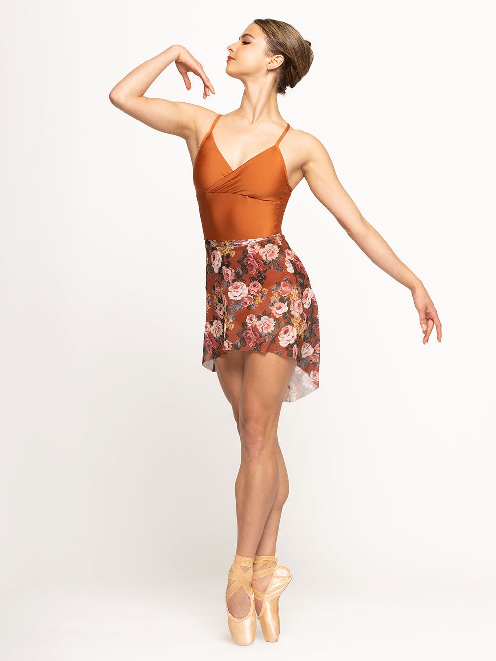 Model is wearing shiny orange wrap halter top leotard with matching orange floral print mesh skirt