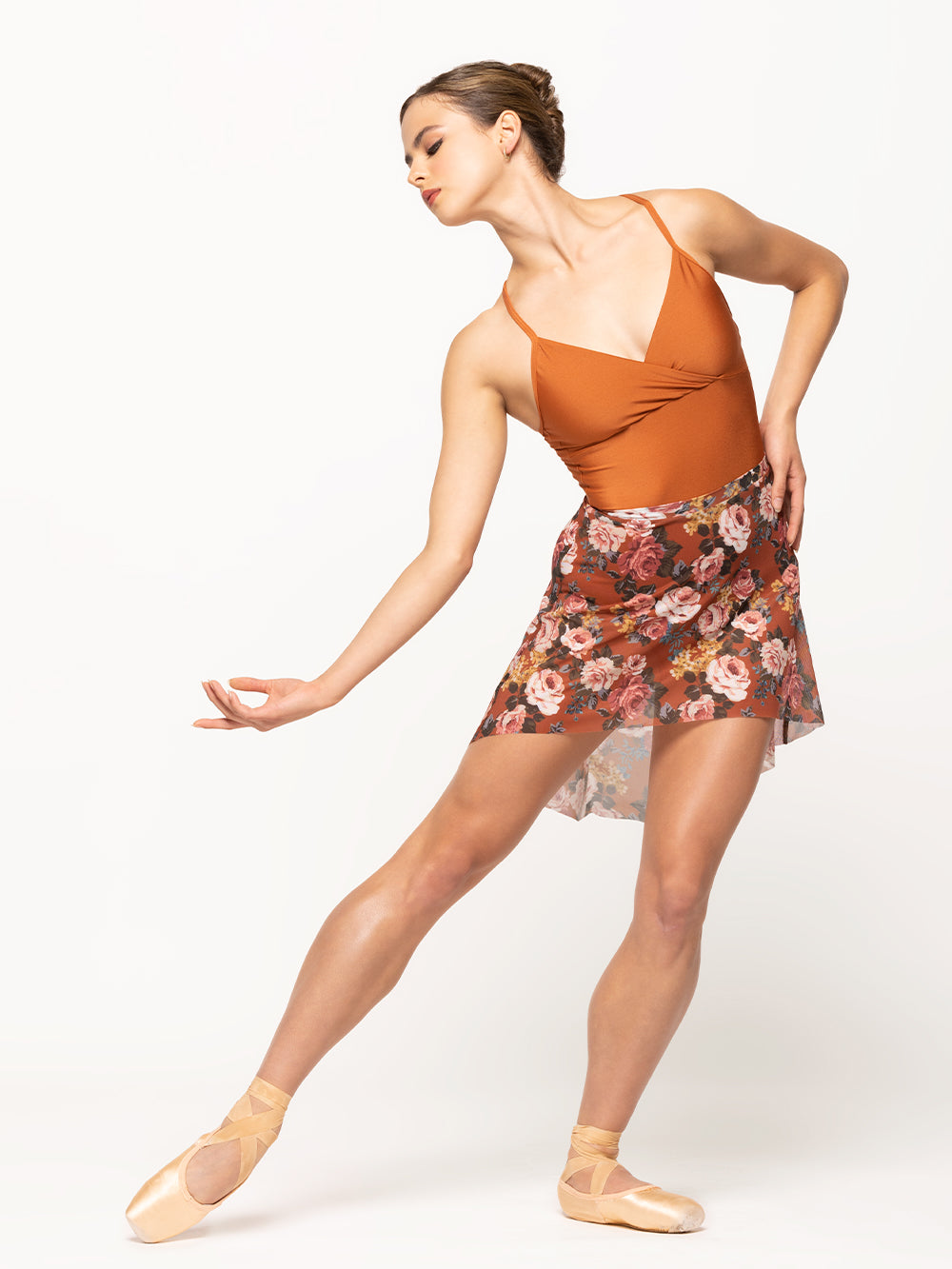 Model is wearing shiny orange wrap halter top leotard with matching orange floral print mesh skirt