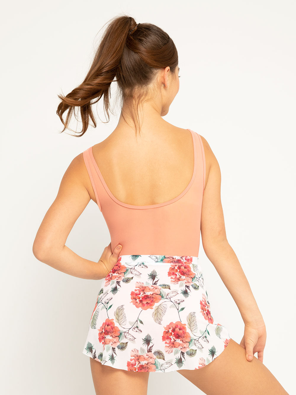 Back of Model is in Light peach leotard with white base floral mesh skirt