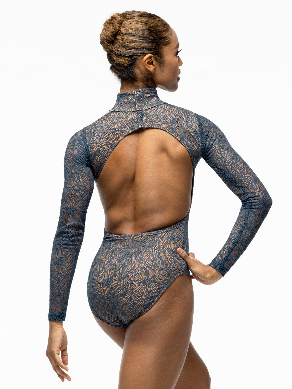 Back of model wearing brown nude leotard with teal lace overlay, high neck, open back, and long sleeves.
