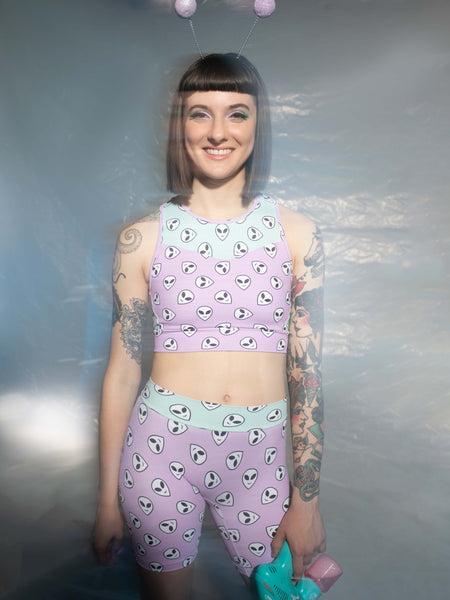 Front view of model in Orchid pink and mint green alien face print crop-top and shorts