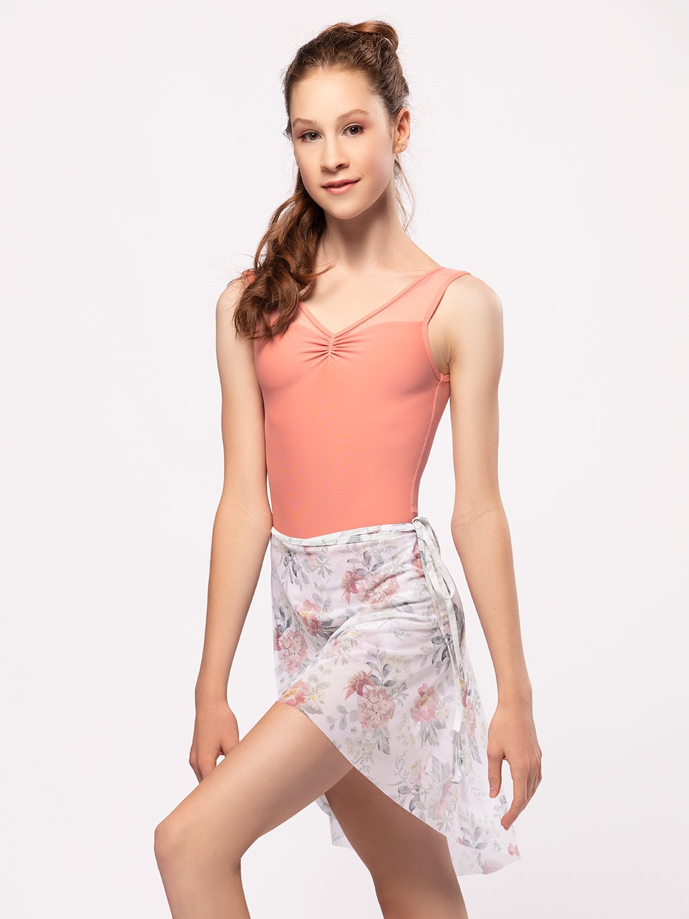 Model wearing a pink leotard with a matching long floral dance wrap skirt