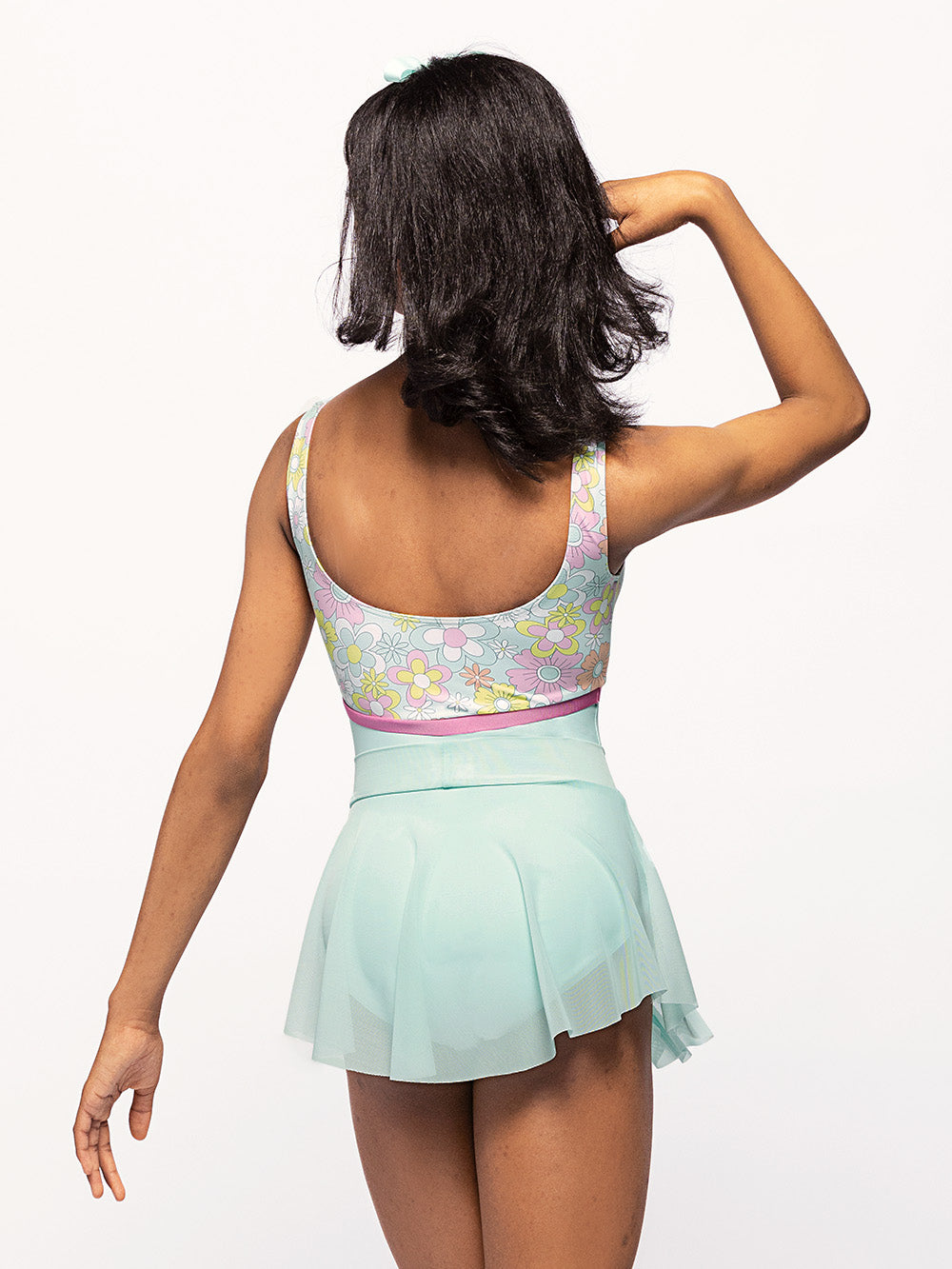back of Model is in pool blue based leotard with floral print top front and pink belt