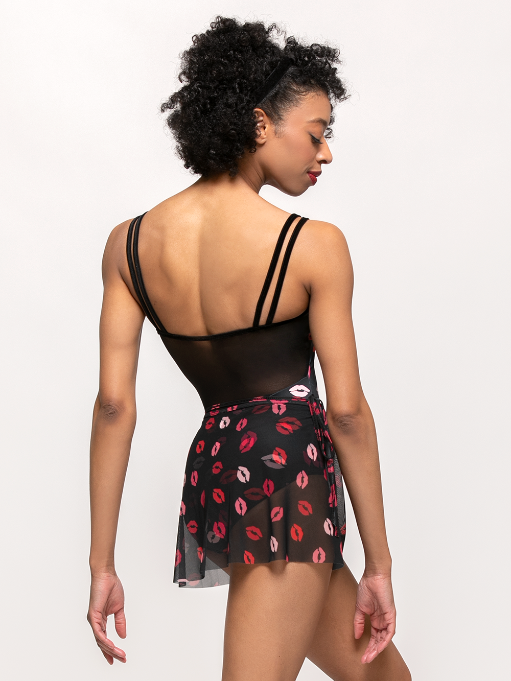 model showcasing back of short black mesh skirt with puckered lip pattern