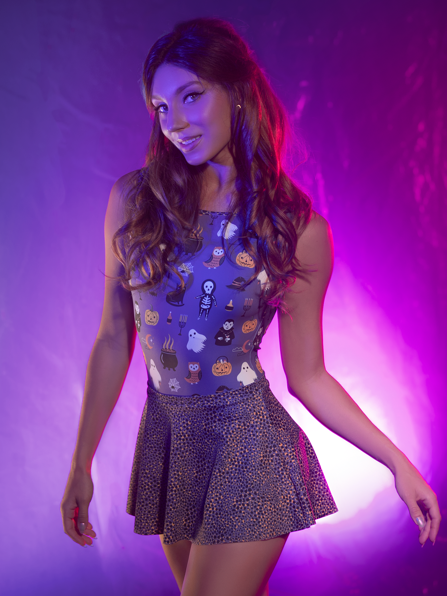 Front close up of Model in leotard with Halloween characters on purple background with purple plum cheetah print skirt