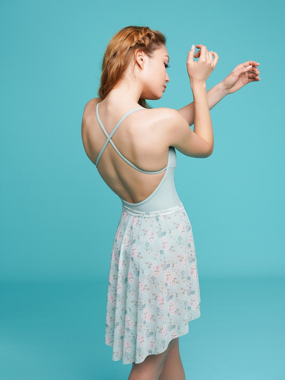 Model wearing light blue cross strap leotard with floral wrap skirt