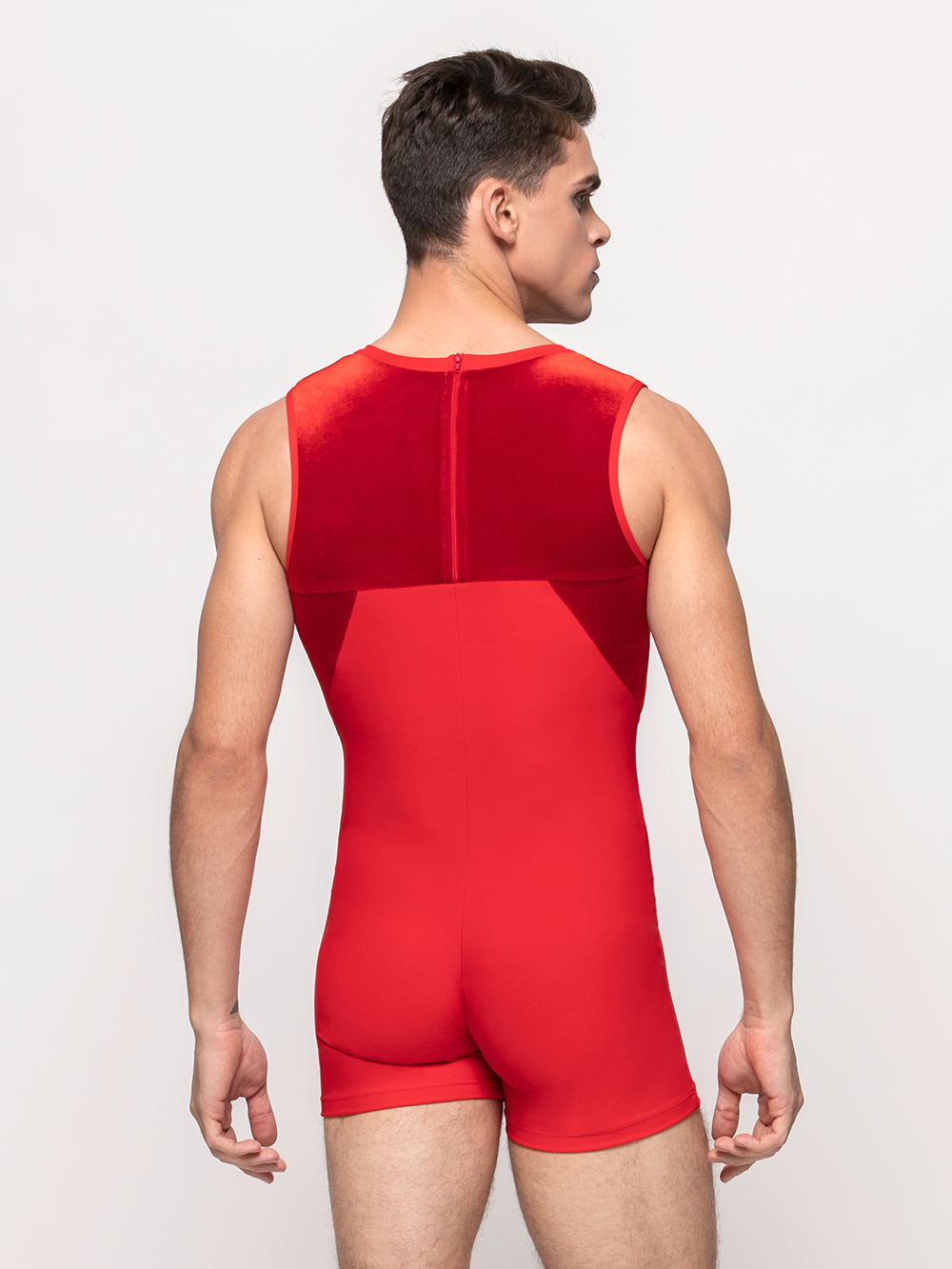 back of model in biketard with red base and red velvet shoulders