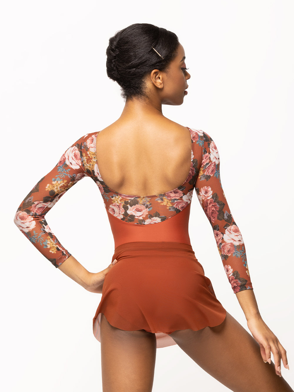 Back of model wearing picante orange leotard with matching orange floral print long mesh top, sleeves, and open back with matching orange mesh skirt