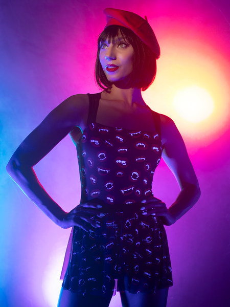 Close up of model in black vampire fang leotard and mesh skirt with hands on hips