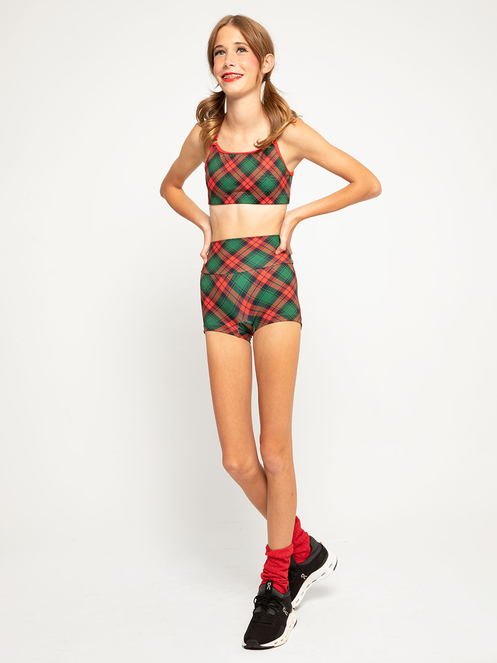 Model is in red knitted ankle length leg warmers in nutcracker leotard with matching plaid crop top and shorts