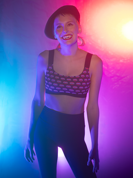 Front of woman in vampire fang cop top  and soft black pants