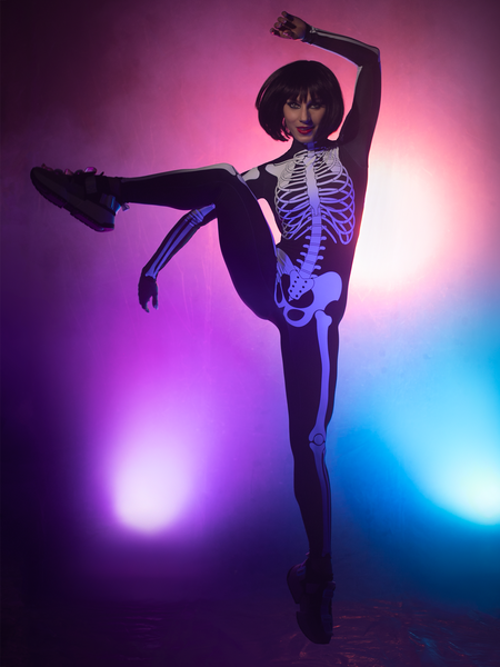 Model in X-ray Skeleton Unitard in kicking pose  