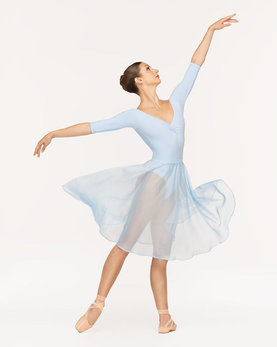 Eleve Dancewear Chiffon Rehearsal Skirt in True Blue color, profile view of dancer on tendu derriere