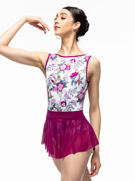 Model is wearing magenta mini mesh skirt with wide waistband. Paired with white and magenta floral print leotard.