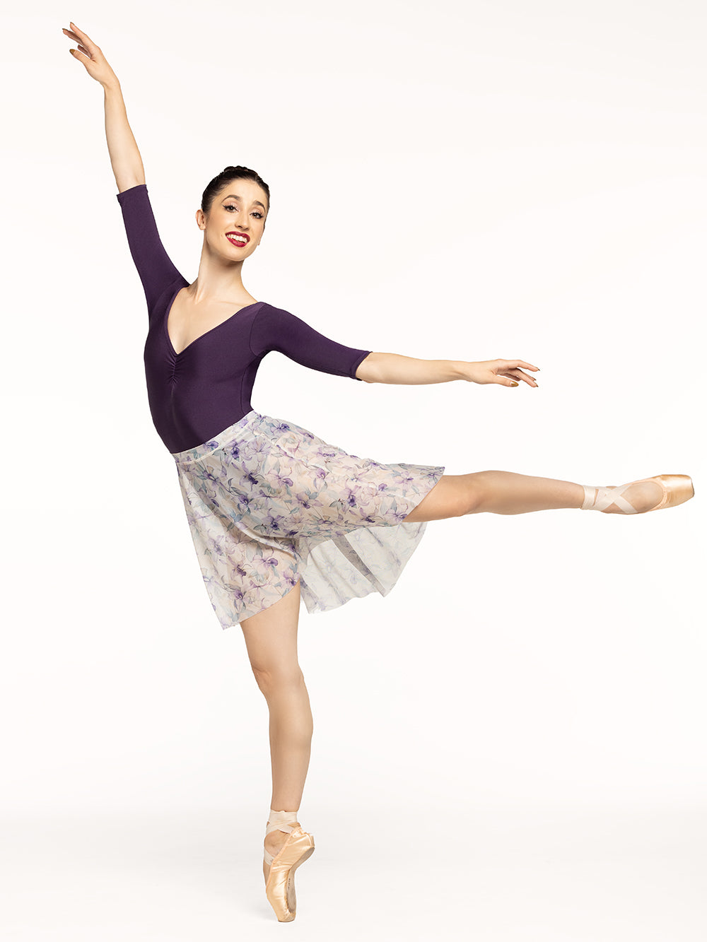 Eleve Dancewear Back Tuck Skirt in Wild Orchid print, front view of dancer posing on arabesque.