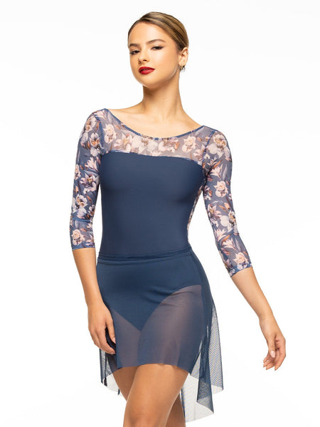 Model is wearing navy blue bodysuit with long floral print mesh sleeves paired with matching blue mesh high low skirt.