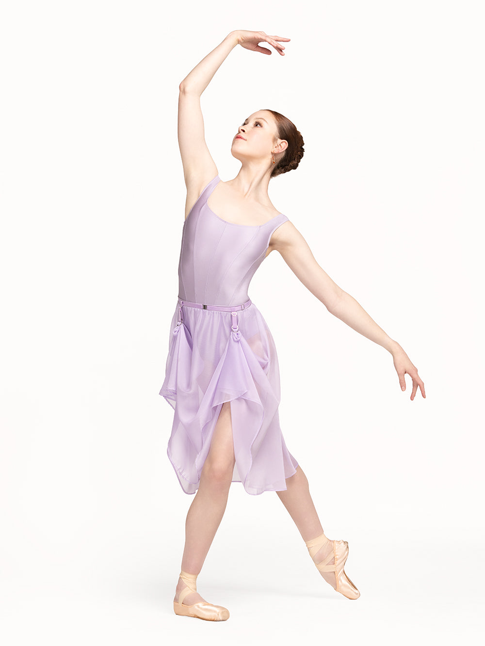 Eleve Dancewear Bustle Belt in Iced Lilac color, front view of dancer posing on tendu derriere croise epaulement.