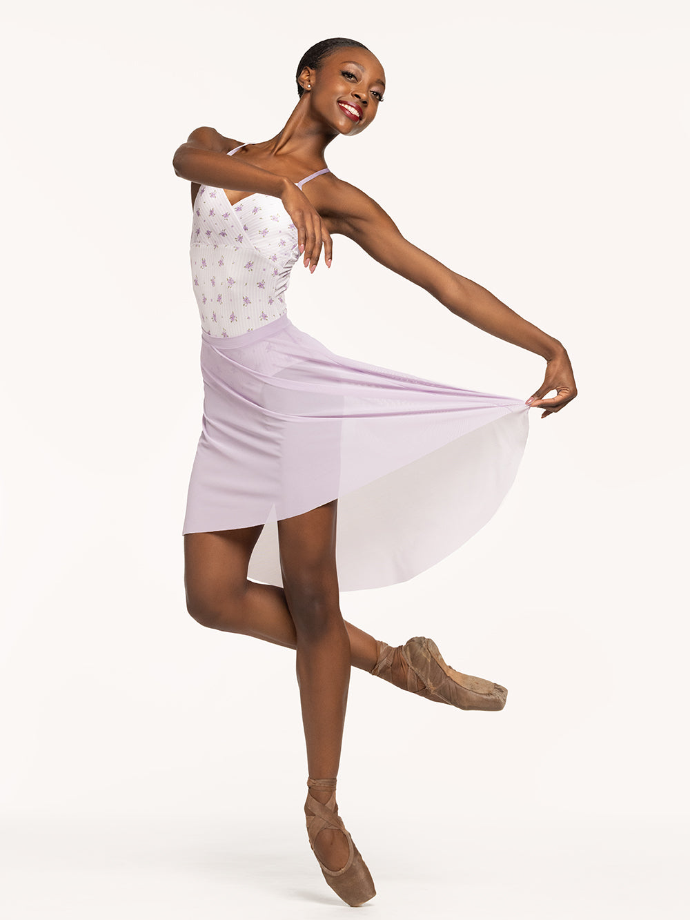 Eleve Dancewear Naomi Leotard in Love Poem print, front view of dancer posing on cou-de-pie on point.