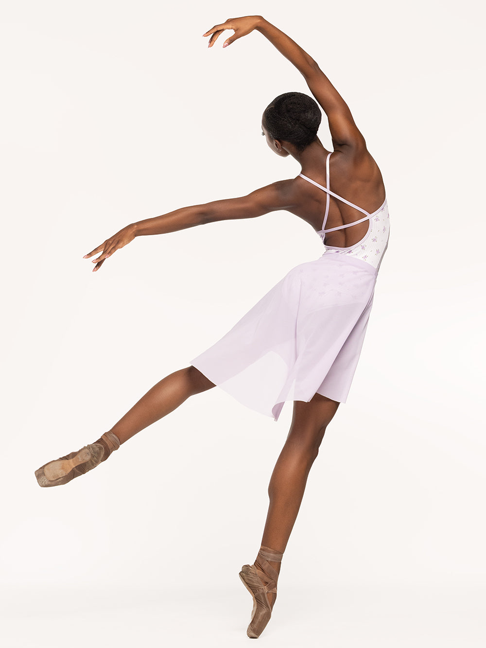 Eleve Dancewear Naomi Leotard in Love Poem print, back view of dancer posing on arabesque epaulement.