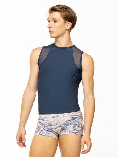 Model is wearing navy blue men's sleeveless top with mesh detail and blue, gold, and white ink swirl print activewear shorts.