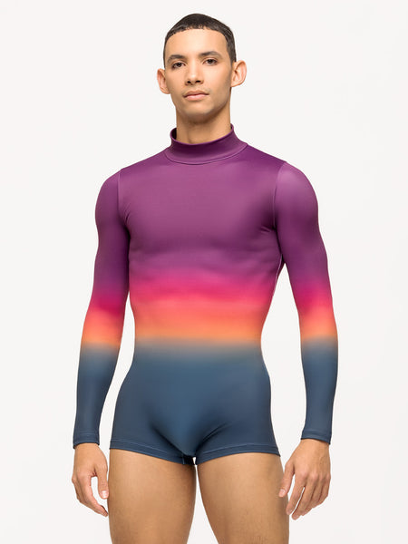 Model is wearing short mens bodysuit in rainbow ombre print with long sleeves.