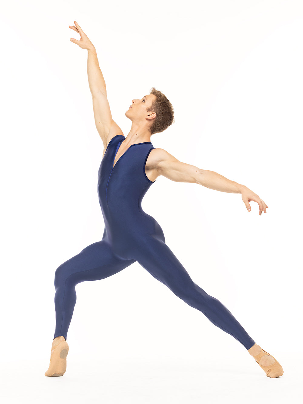 Eleve Dancewear Nathan Unitard in Sapphire color, profile view of dancer posing on long four on releve devant.