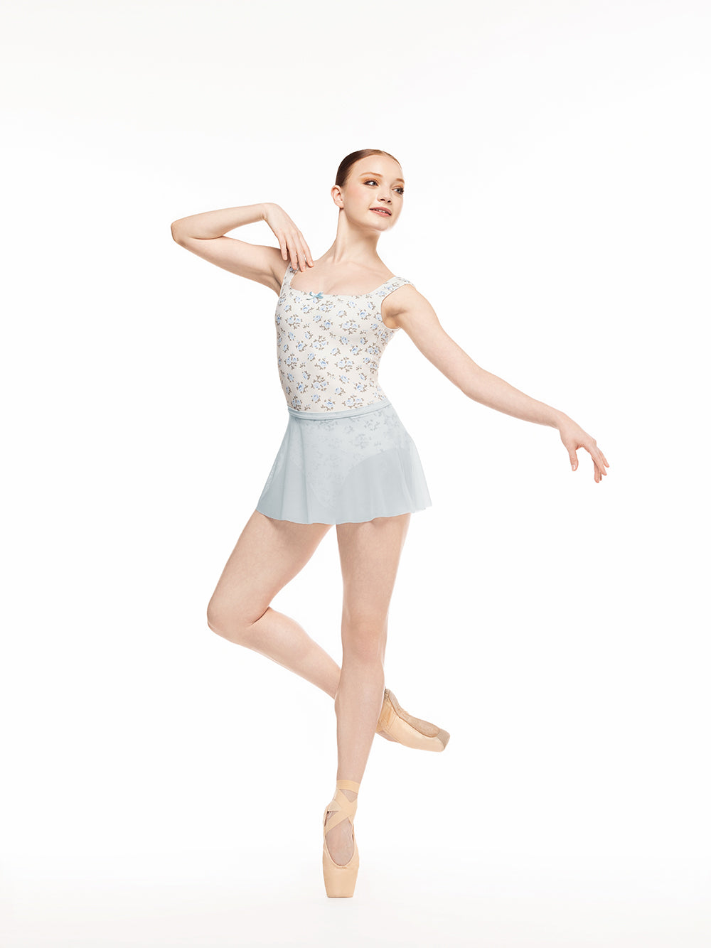 Eleve Dancewear Flare Skirt Kids in Frost Mesh print color, front view of dancer on cou-de-pie on point