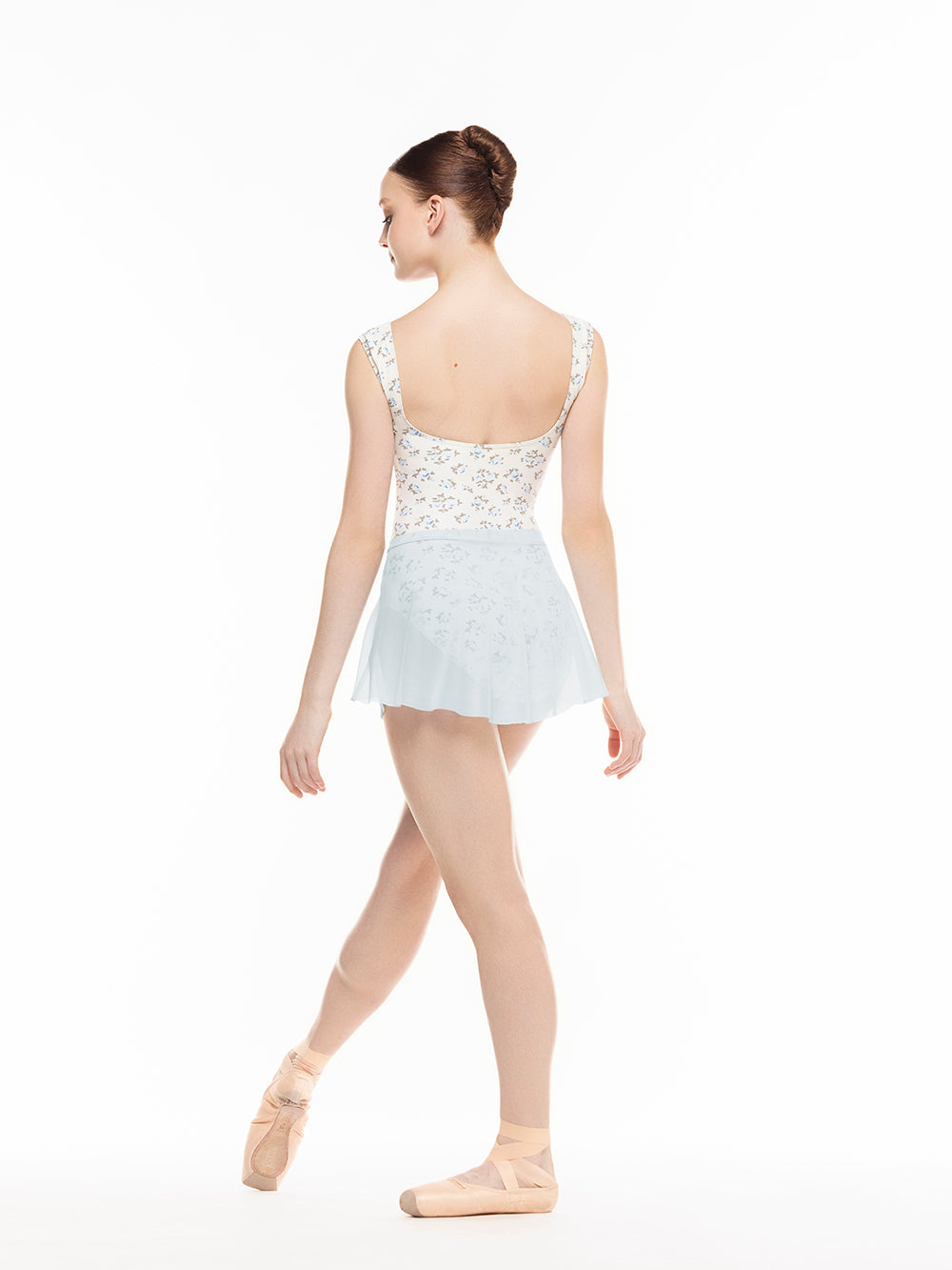 Eleve Dancewear Flare Skirt in Frost Mesh print color, back view of dancer on tendu devant croise