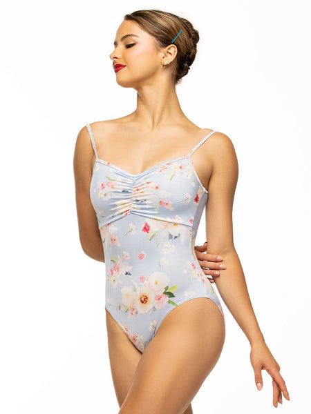 Model is wearing light blue floral print bodysuit with gathered front and mesh back.
