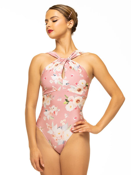 Model is wearing shiny pink floral print bodysuit with twist halter neck and keyhole detail.