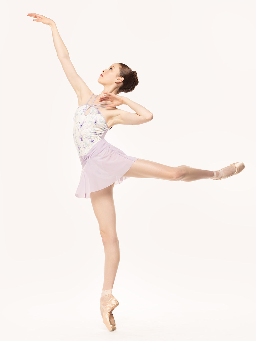 Eleve Dancewear Amora Skirt in Iced Lilac print color, profile view of dancer posing in arabesque attitude.