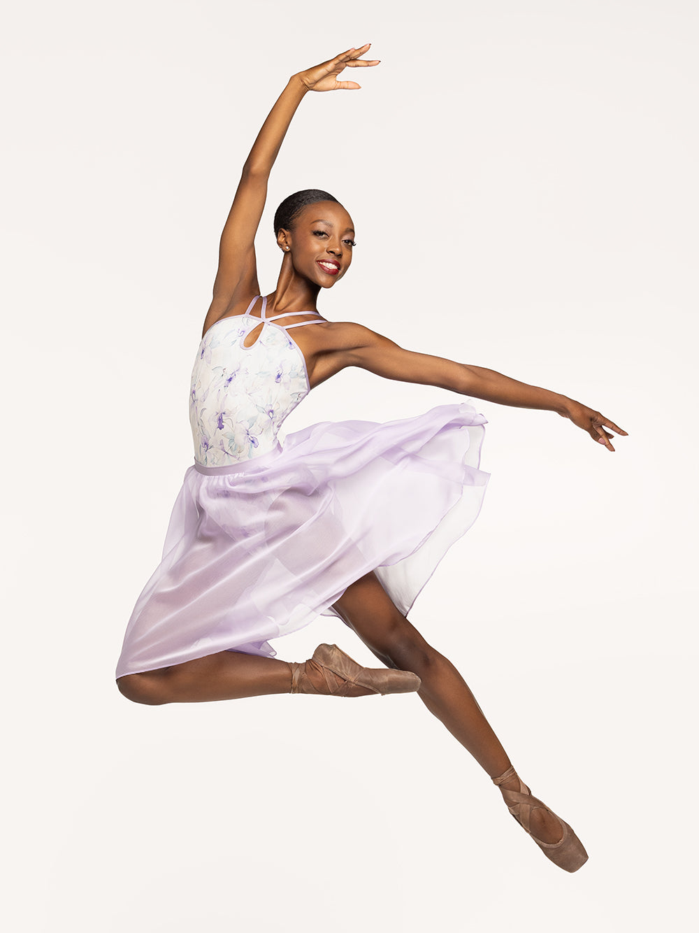 Eleve Dancewear Noelle Leotard in Wild Orchid print, front view of dancer jumping on passe.