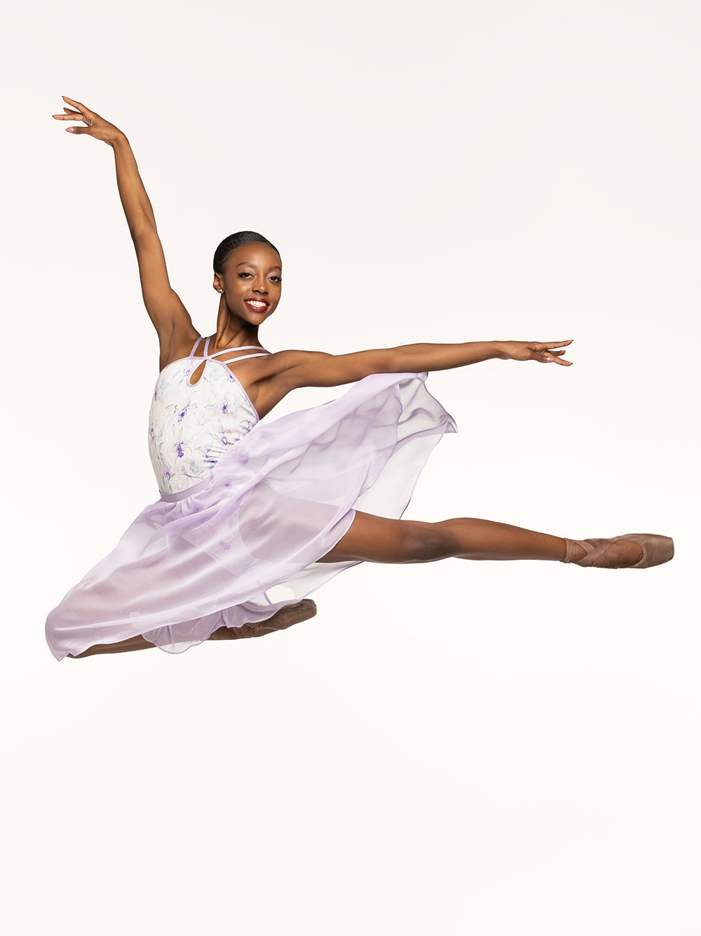 Eleve Dancewear Noelle Leotard Kids in Wild Orchid print, front view of dancer on passe arabesque.