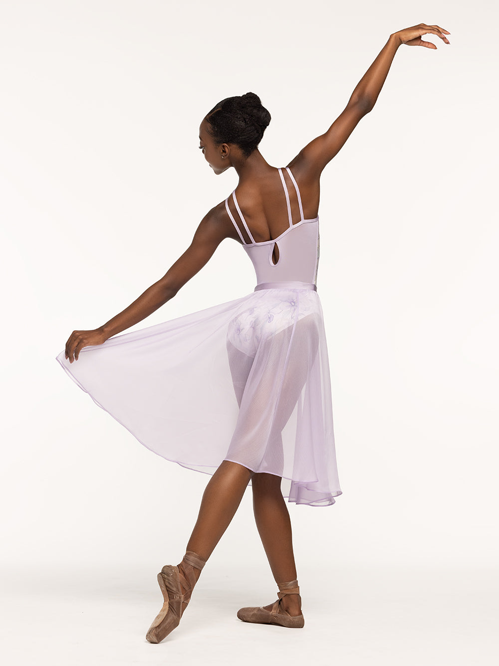 Eleve Dancewear Noelle Leotard in Wild Orchid print, back view of dancer posing on tendu derriere.