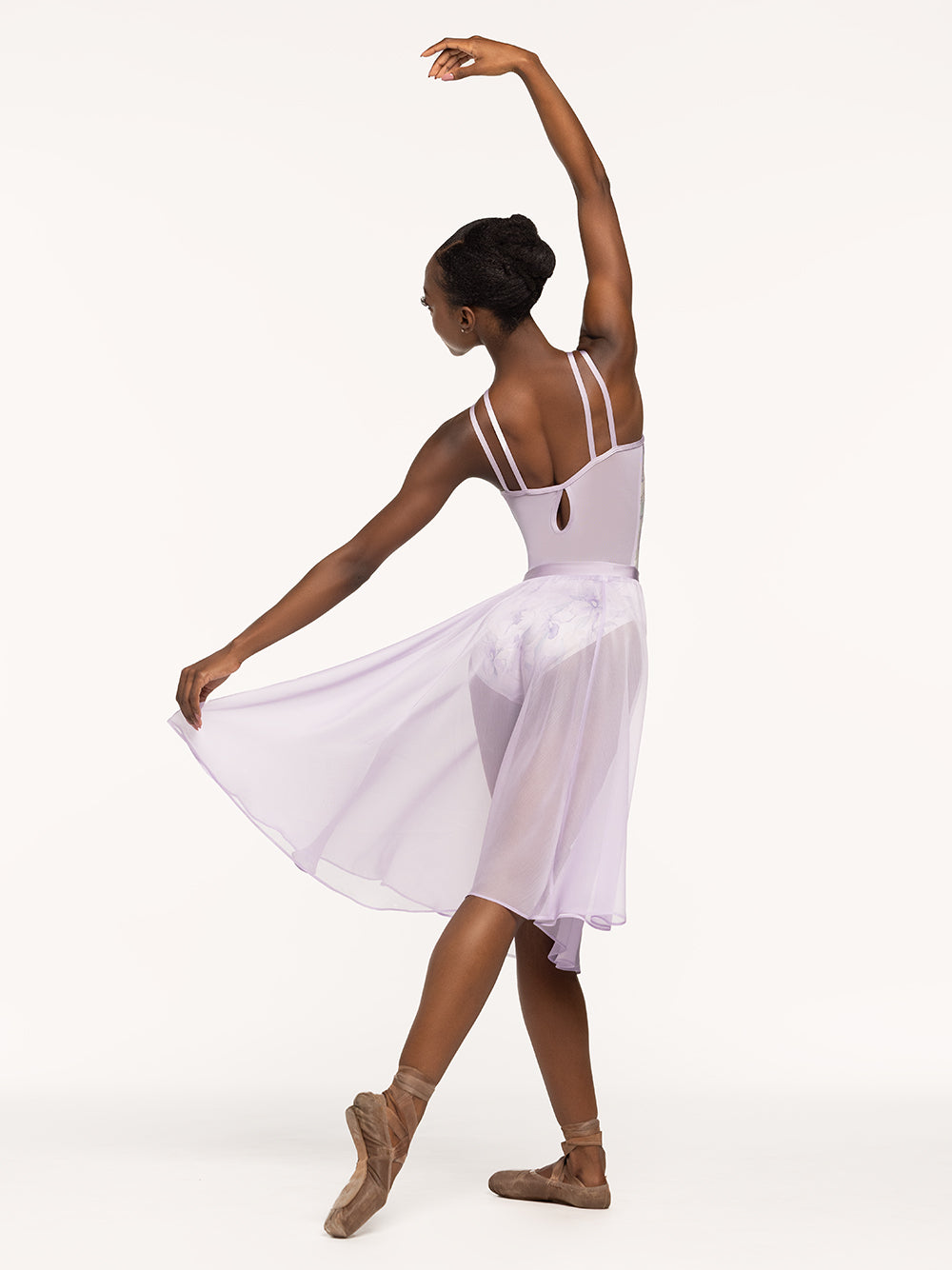 Eleve Dancewear Noelle Leotard Kids in Wild Orchid print, back view of dancer posing on tendu derriere.