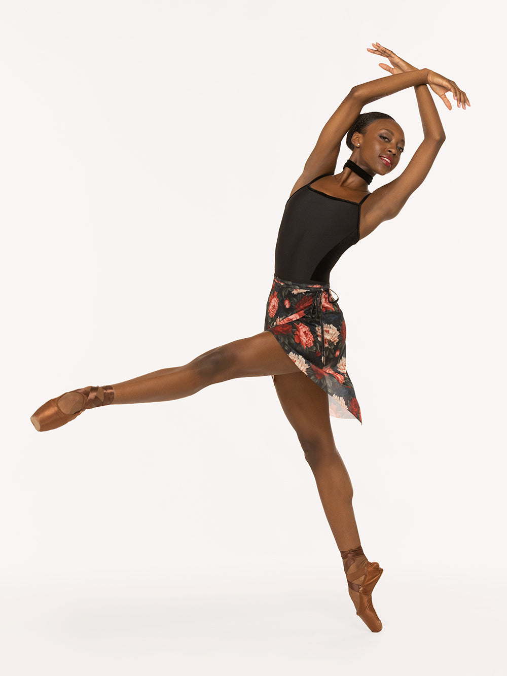 Eleve Dancewear Vienna Mid High-Low Wrap Skirt in Winter Florals Mesh print, front view of dancer leaning low devant pique