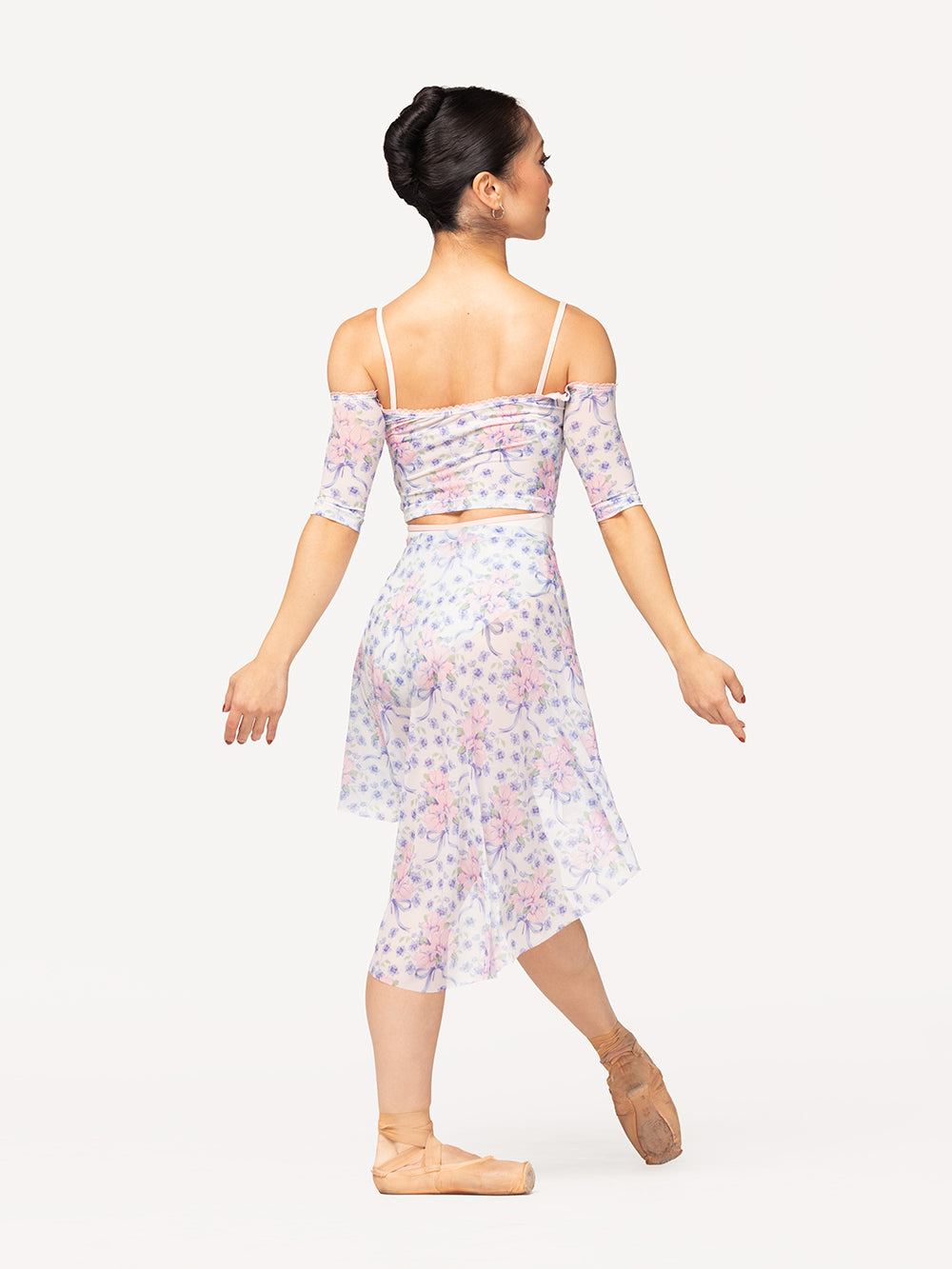 Eleve Dancewear Candy Leotard in Stage White color, back view of dancer on tendu devant croise