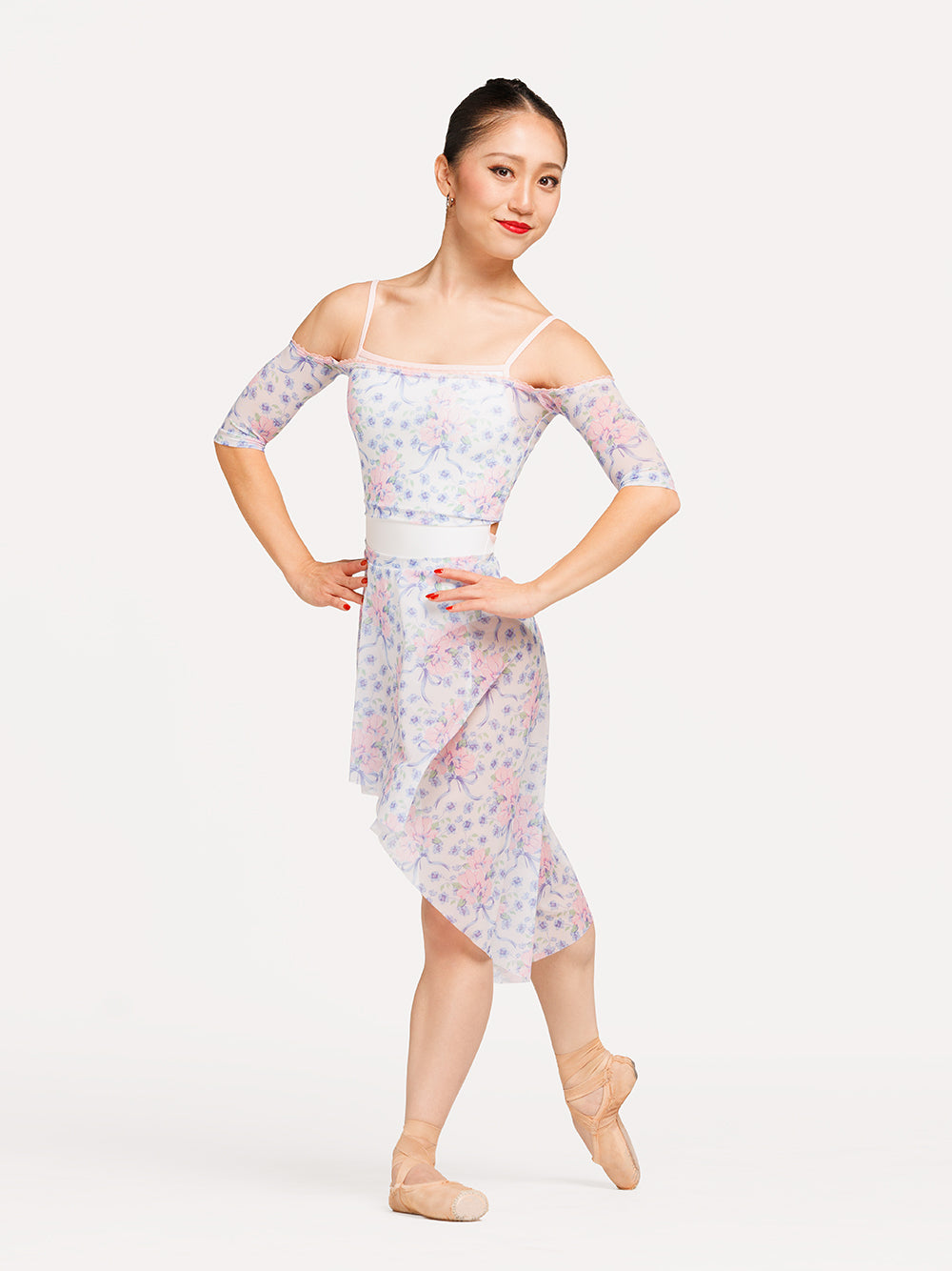 Eleve Dancewear Long High-Low Skirt in Flowers & Bows Mesh print, detail front view of dancer on tendu derriere croise